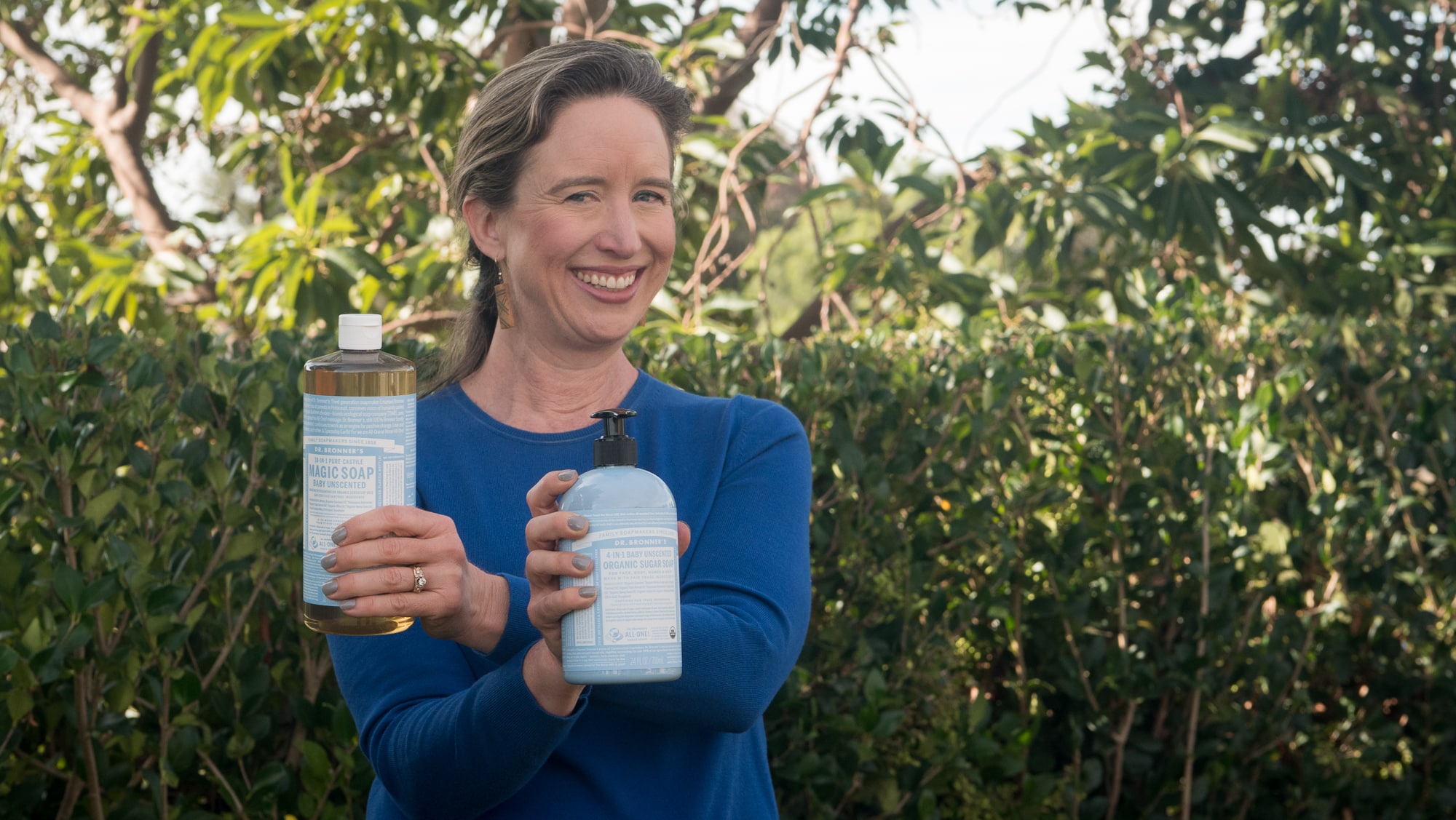 Lisa holding Dr. Bronner's Magic Soap and Sugar Soap