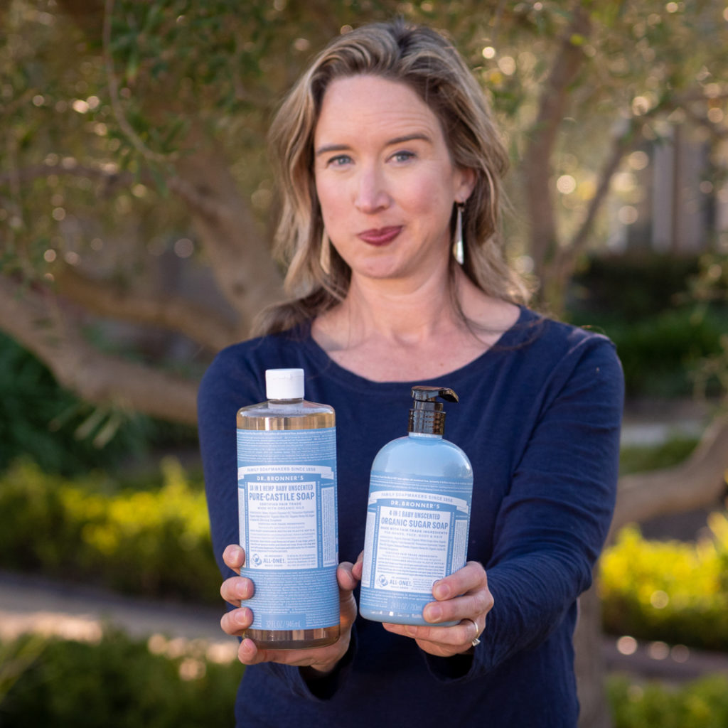 Lisa Bronner holding Dr. Bronner's Unscented Castile Soap and Sugar Soap