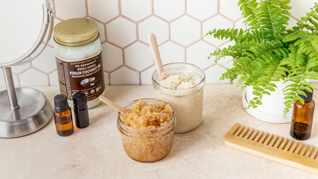 Two glass jars filled with body scrubs made of sugar and coconut oil. GIY Coconut Sugar Scrub