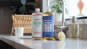 Dr. Bronner's Sal Suds and Castile Magic Soap next to sink in kitchen.