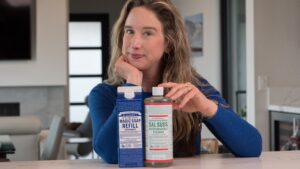 Lisa sitting at counter with Dr. Bronner's Castile Magic Soap and Sal Suds.