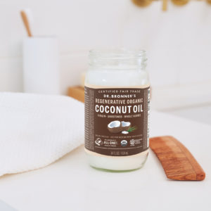 An opened jar of coconut oil on a counter.
