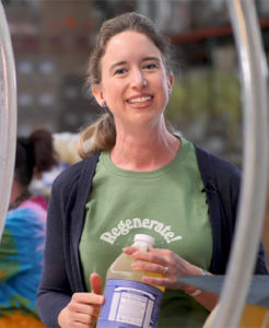 Lisa Bronner holding a bottle of Dr Bronner's soap.