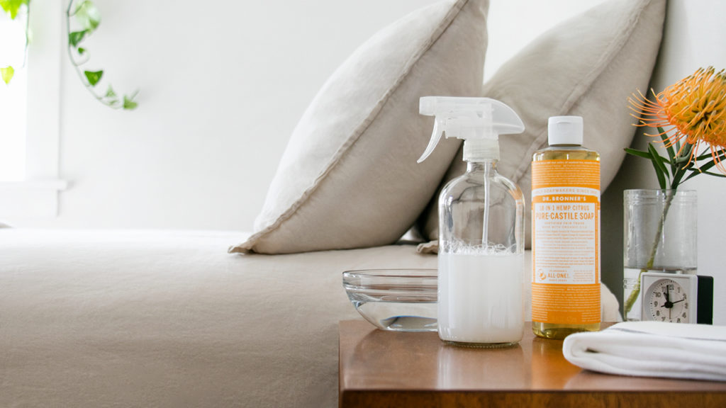 Dr. Bronner's Castile Soap and spray bottle on a table. - wipe-off body cleaning spray