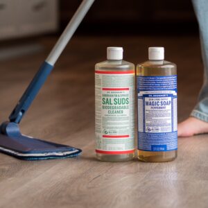 Dr. Bronner's Sal Suds and Castile soap on floor while someone mops behind.