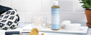 A bottle of Dr. Bronner's Pure-Castile Soap and a makeup brush.