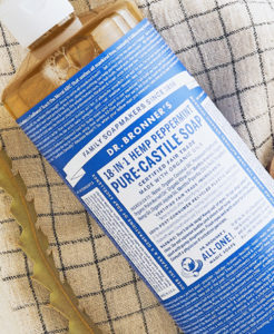 Bottle of Dr. Bronner's Peppermint Castile Soap on a hand towel.