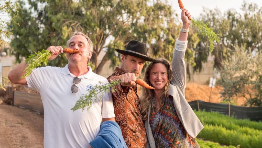 Mike, David, and Lisa Bronner holding carrots and being silly at Coastal Roots Farm in Encinitas, CA.