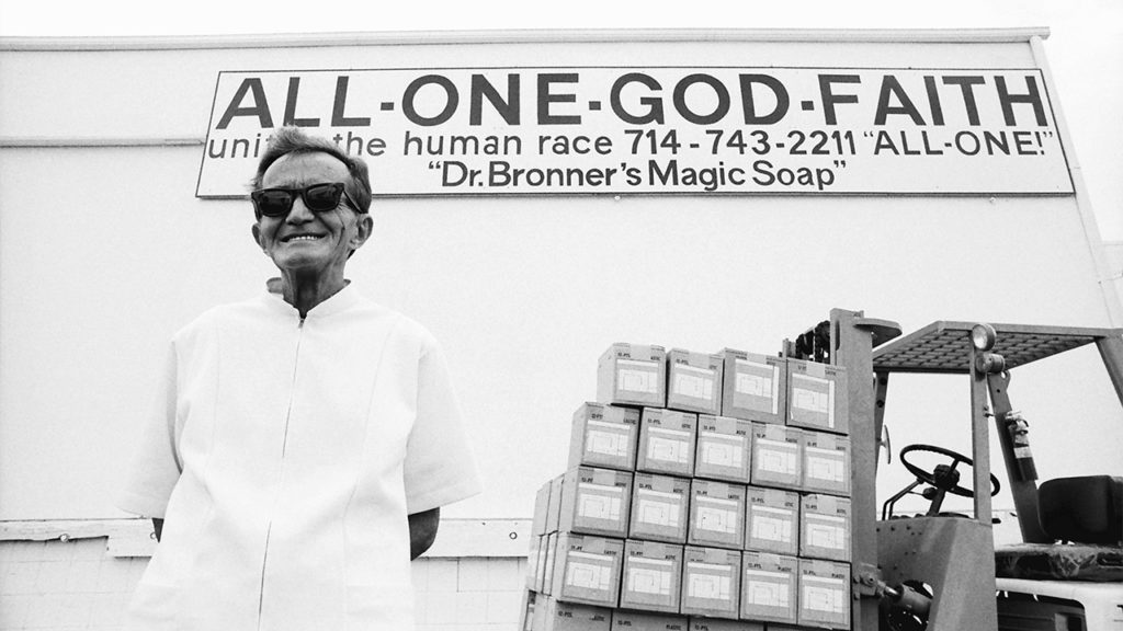 Black and white photo of Dr. Emanuel Bronner standing in front of the Dr. Bronner's soap factory.