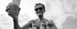 Dr. Bronner holding bottles of Castile Soap