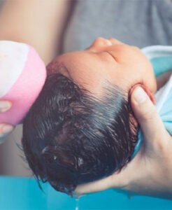 Woman washing a baby's hair.