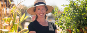 Lisa Bronner in a home garden with corn and tomatoes