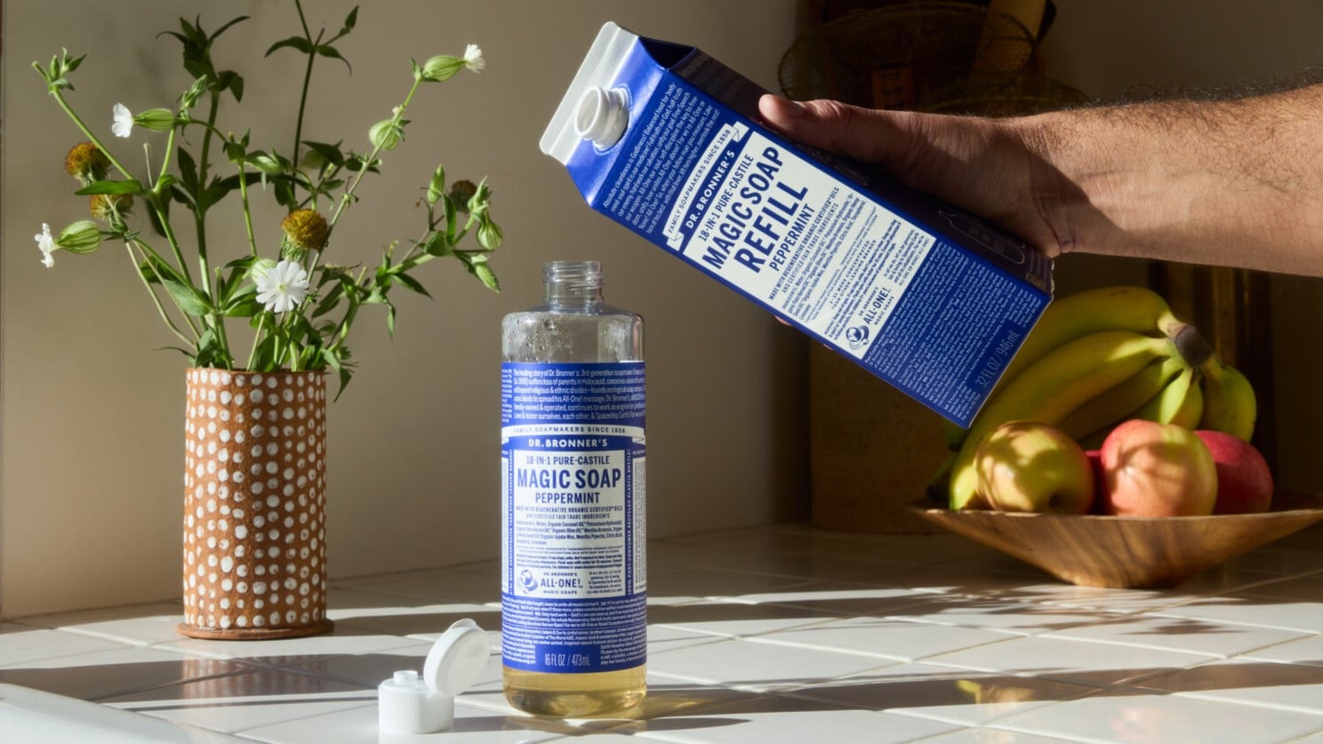Dr. Bronner's Castile Magic Soap Refill carton, refilling a PCR container.