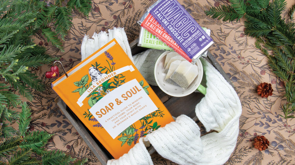 Soap & Soul book with tea, Dr. Bronner's Magic Chocolate and greenery.