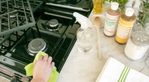 Cleaning a stove with Dr. Bronner's Sal Suds and Castile Soap on counter