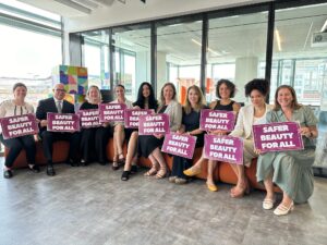 Women holding signs that say Safer Beauty for All