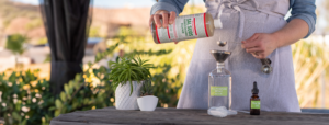 Lisa pouring Dr. Bronner's Sal Suds into a jar labeled "All Purpose Spray"