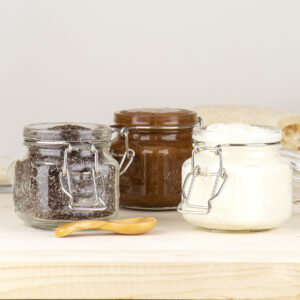 GIY Body Scrubs in glass jars on counter.