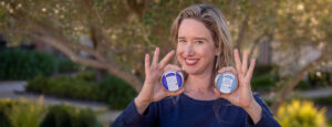 Lisa holding up both magic balms and smiling.
