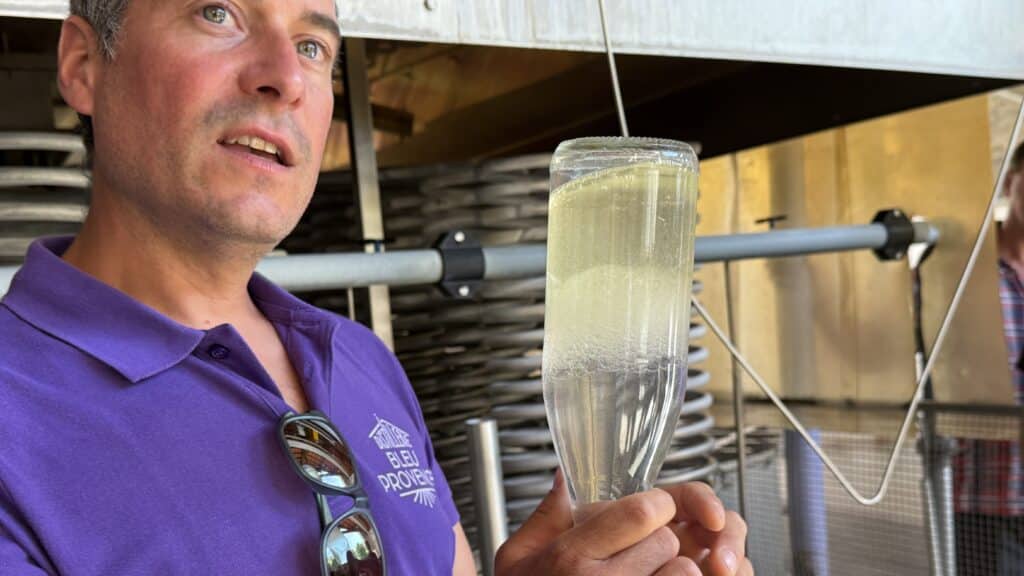 Clément demonstrates the gravity-driven separation of oil and water that occurs in the collection vessel in the distillery’s cellar.
