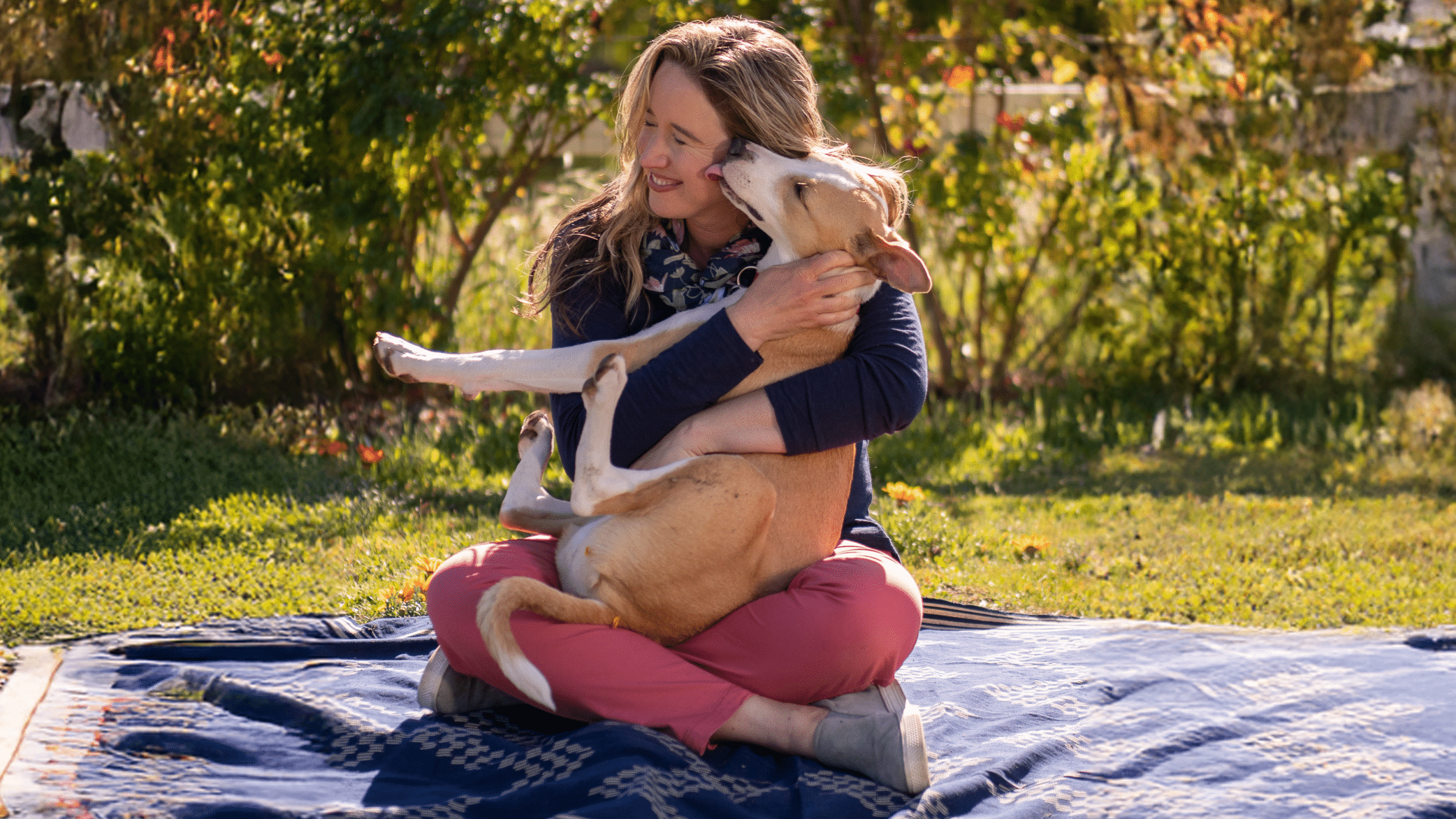 Lisa and her dog Sadie on a picnic blanket.