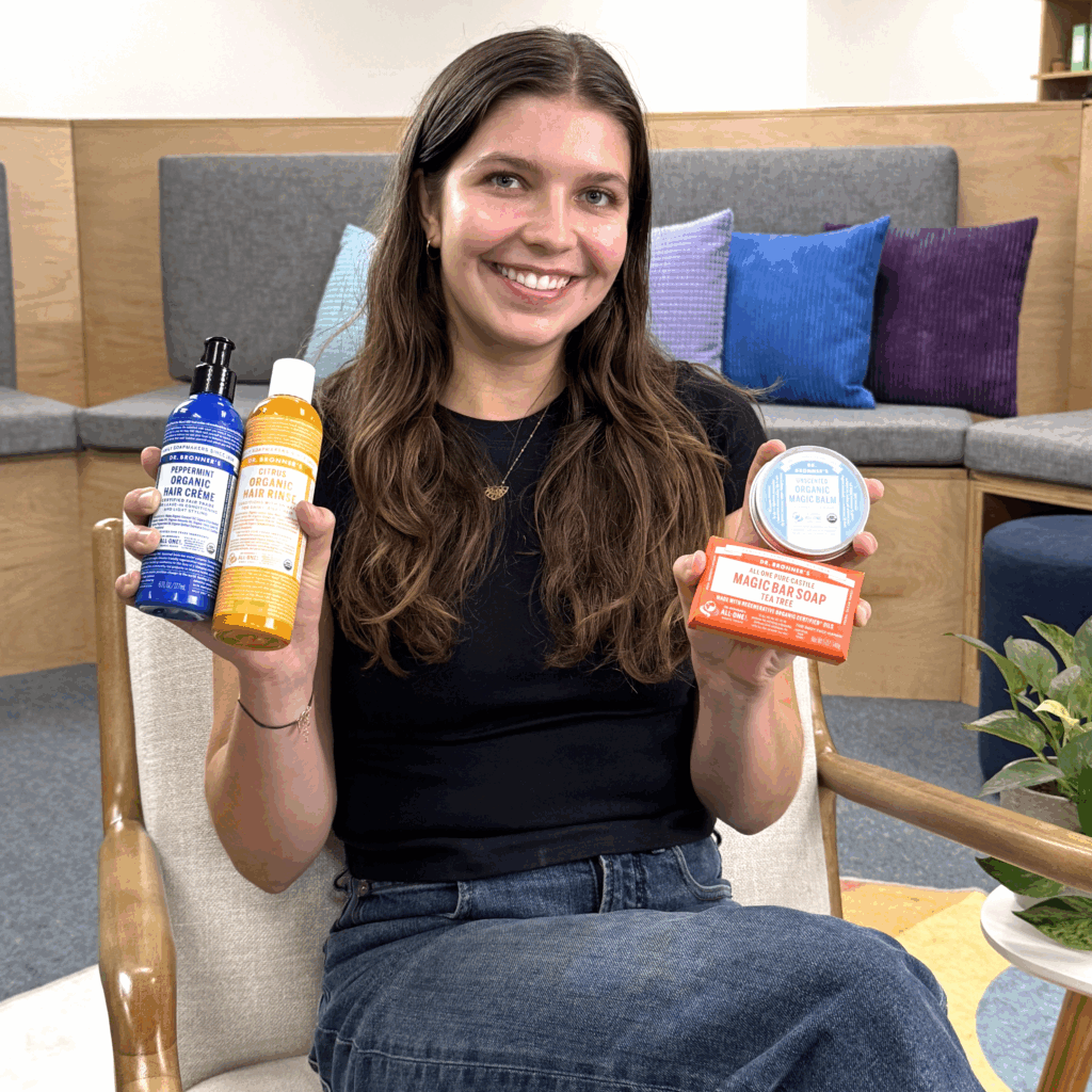 Woman holding Dr. Bronner's products for hair care