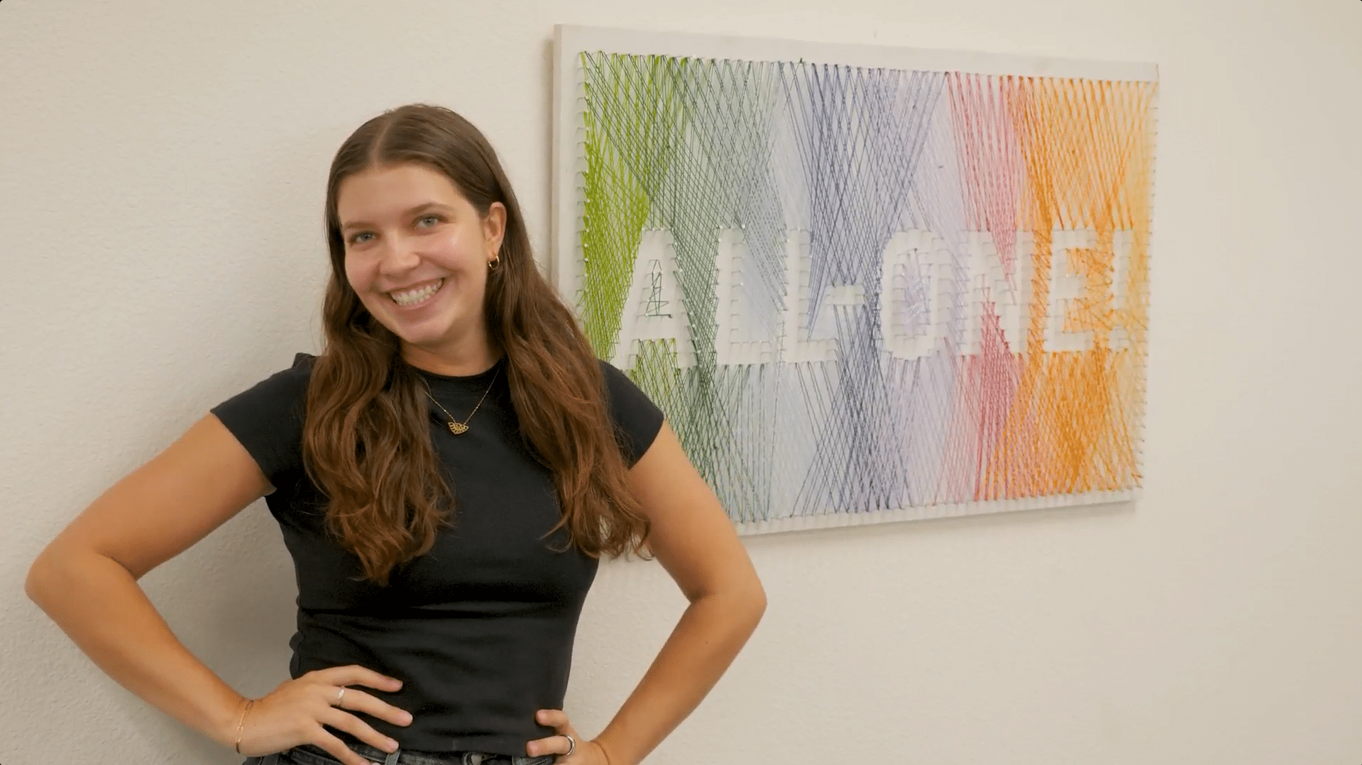 Sofia standing smiling by wall
