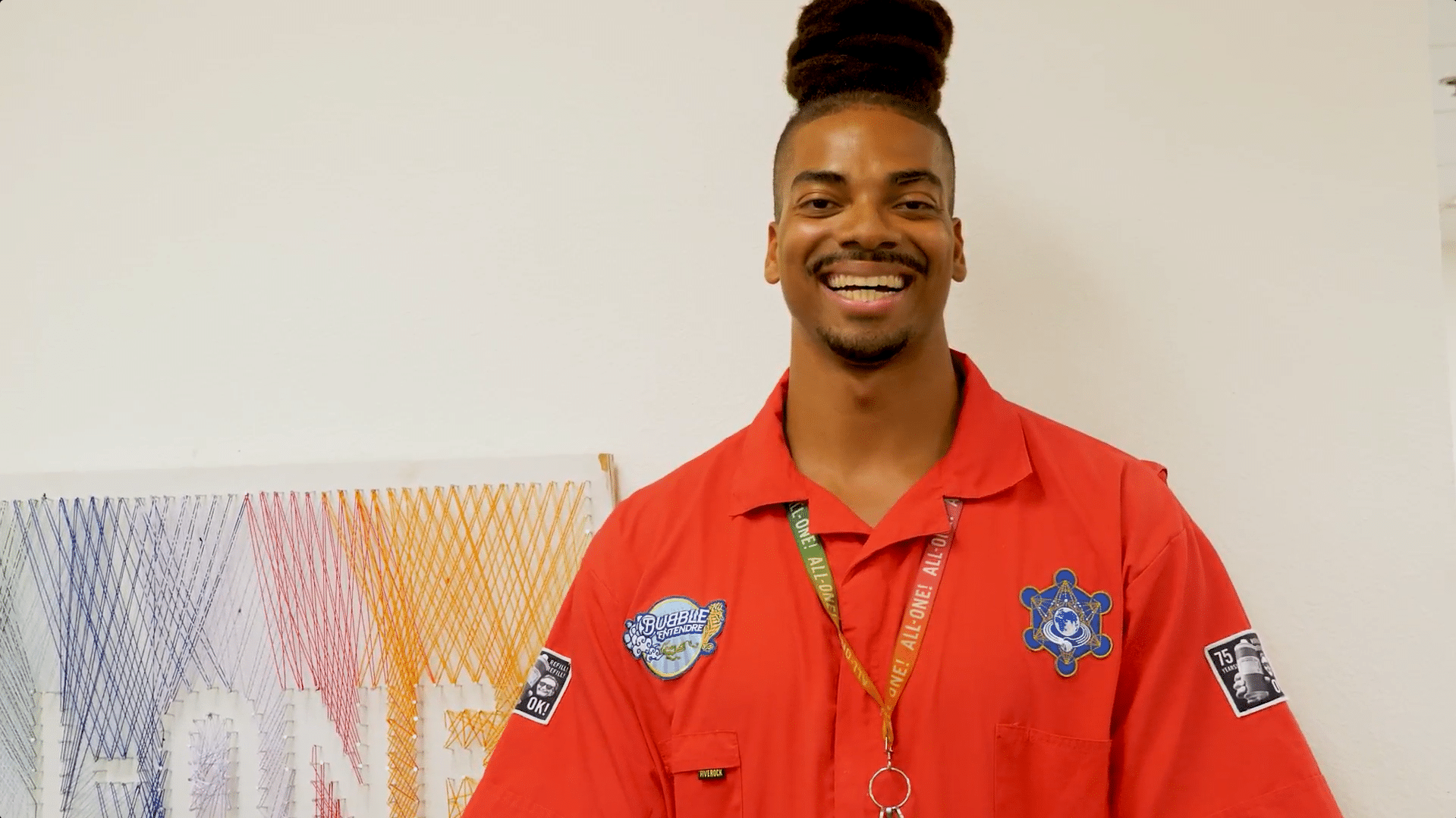 Garrison standing and smiling by wall