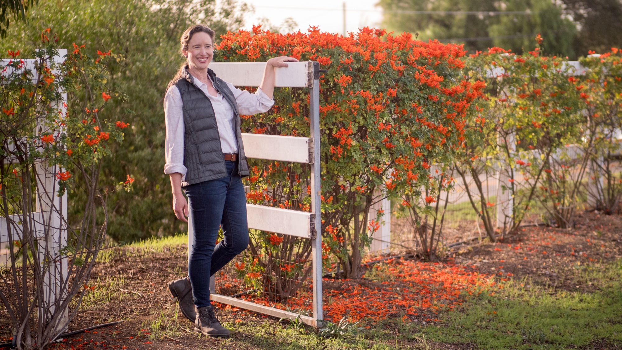 Lisa standing at a gate smiling.