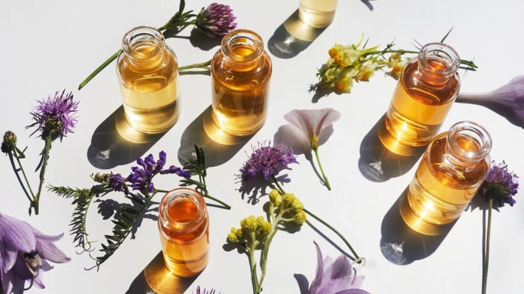 Essential oils and flowers on table.