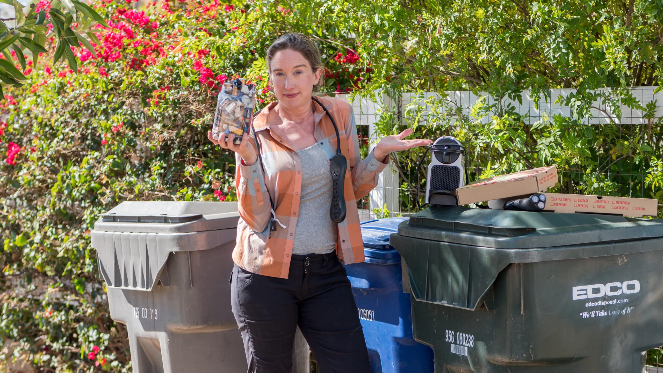 Lisa holding up a jar of batteries wondering how to dispose of it.