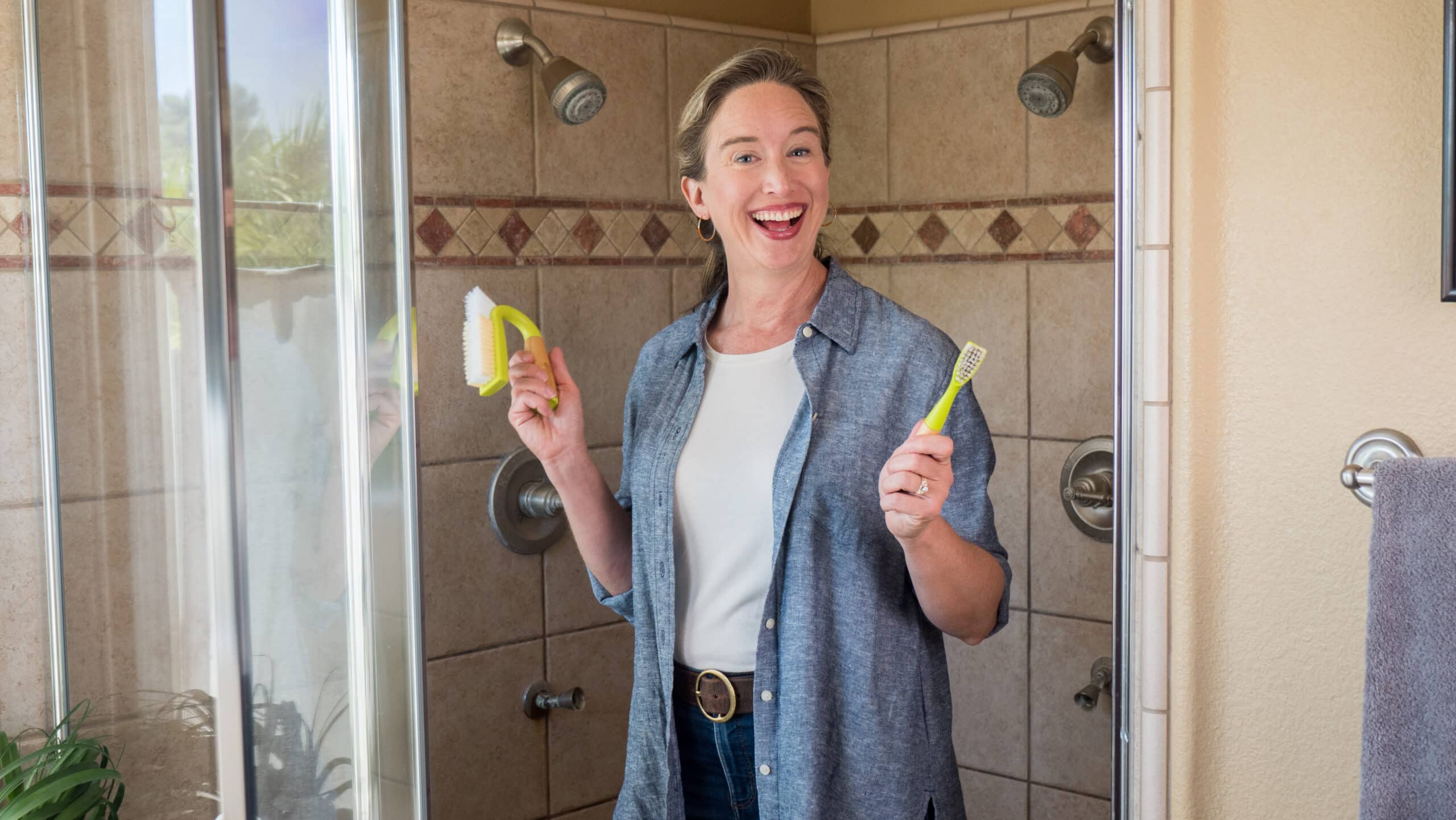 Lisa holding up grout cleaning brushes.