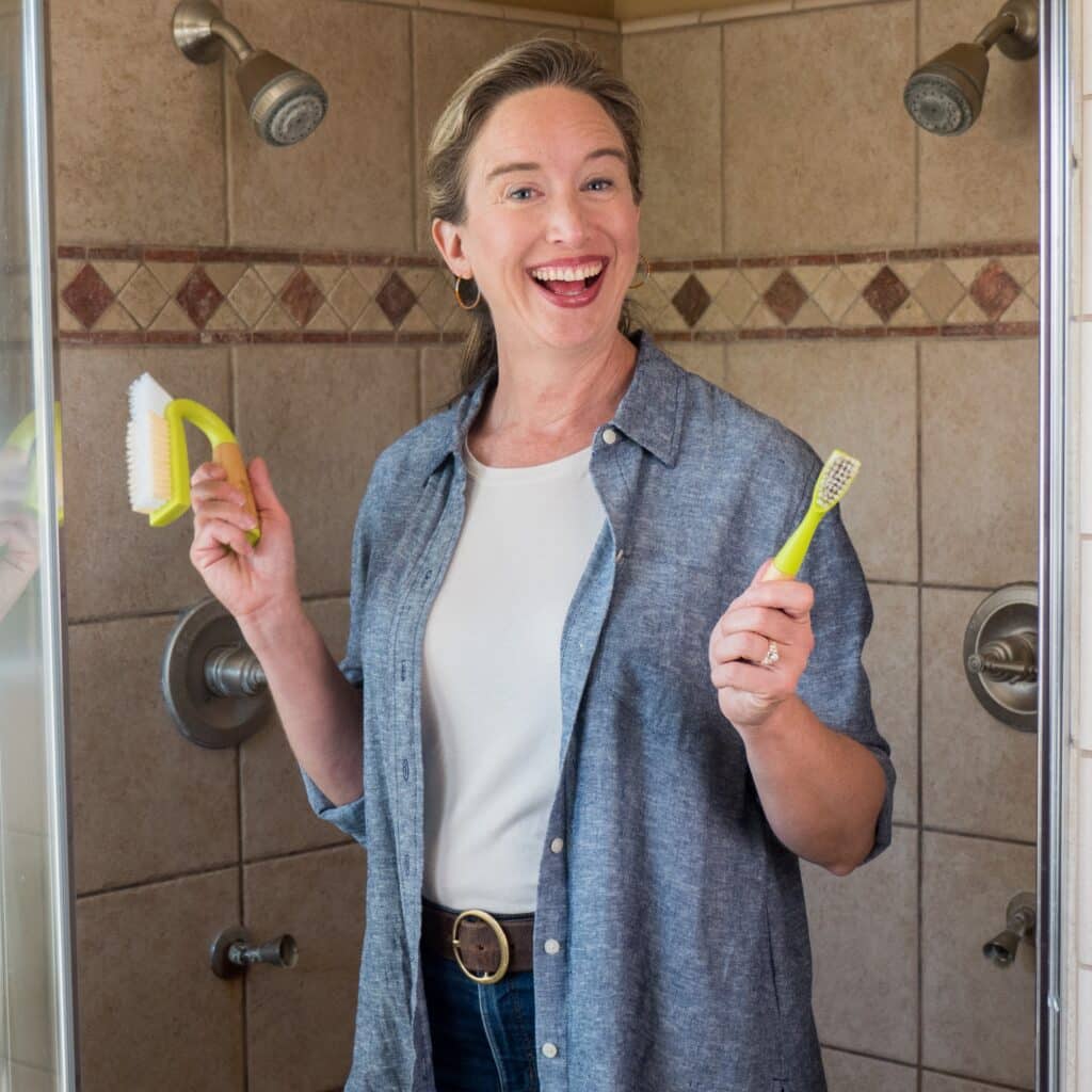 Lisa holding up grout cleaning brushes.